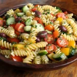 A bowl of vibrant pasta salad with fresh vegetables and herbs, showcasing ideal texture and flavor.